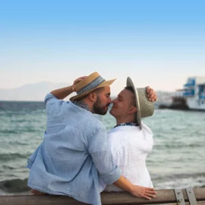 A coiuple of gay smiling and facing each other during an engagement session