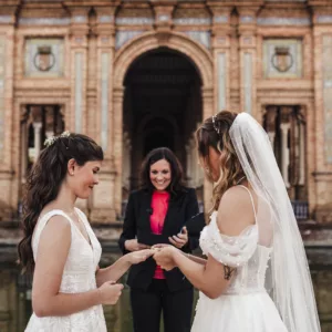 The 2 brides exchanging their vows and sliding the ring