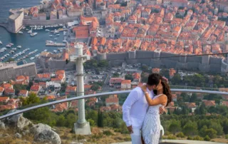 The beautiful backdrop behind the couple, a view over the sea from the balcony above the city