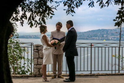 the couple and the celebrant at the balcony of a garden