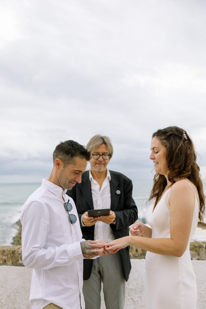 The groom slides the ring to the bride