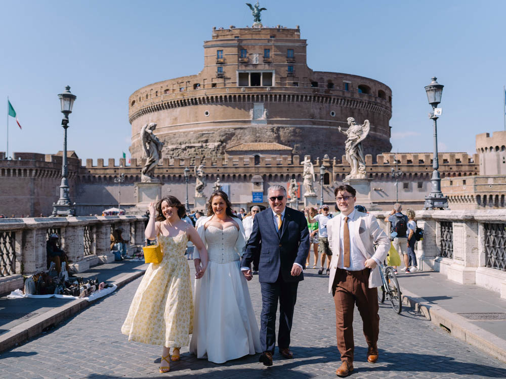 The bride and groom walking and smiling with their daughter and son on the St pierre Bridge