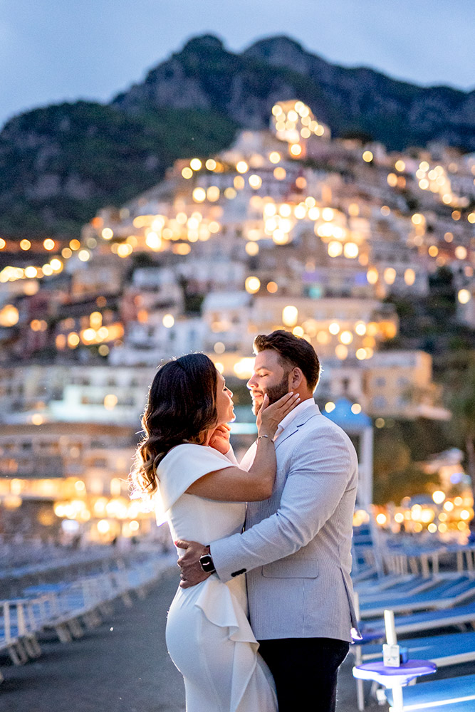 The couple facing each other on the beach by night in Positano