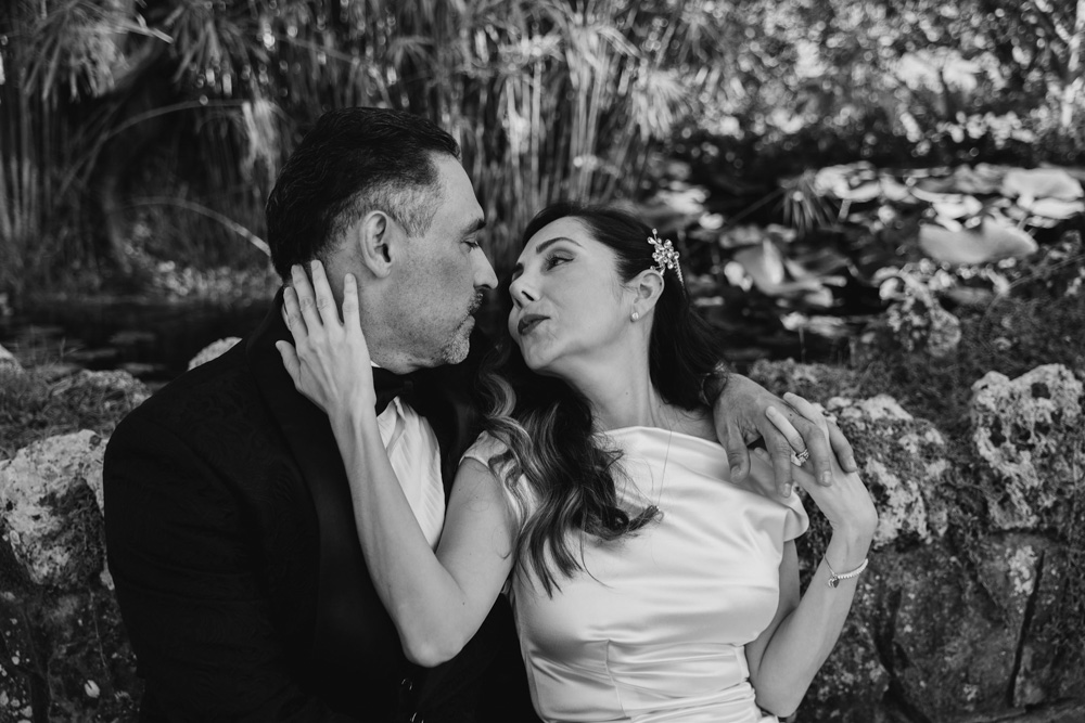 the couple sit on a bench in black and white