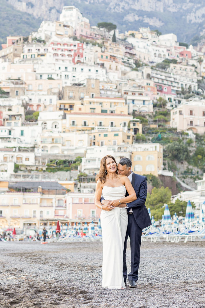 The couple after the ceremony, on the beach with Positano village in the background