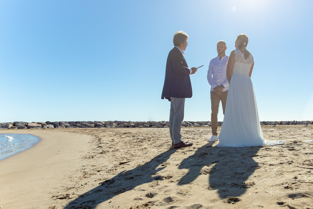 The ceremony stands on the beach, the couple is facing each other