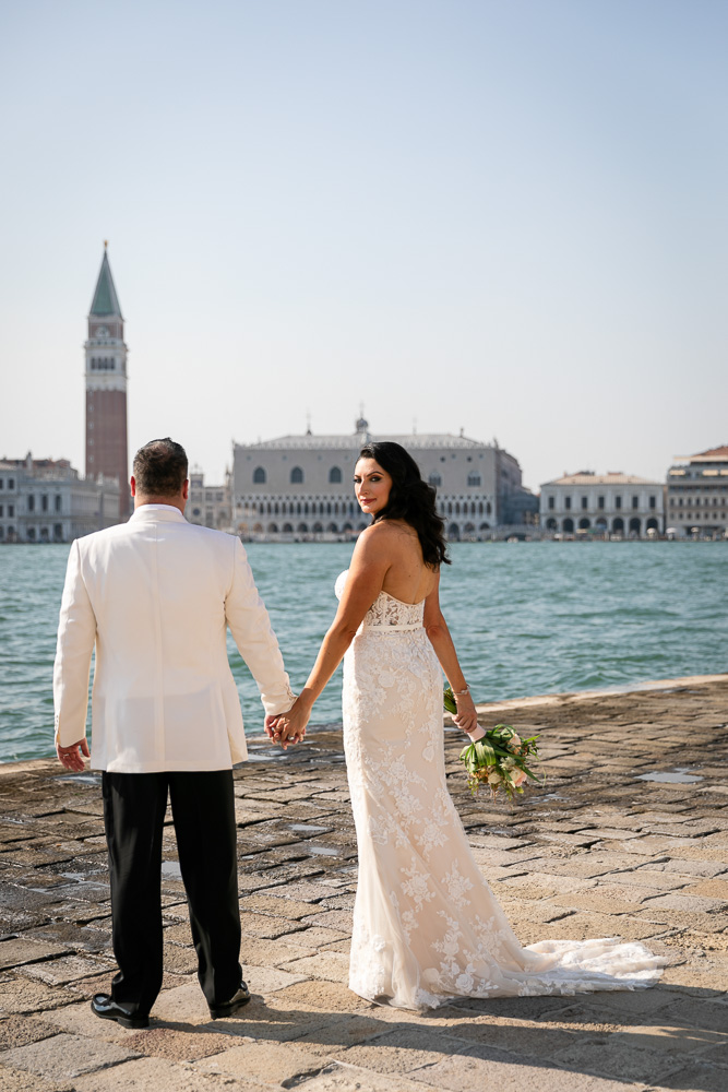 The bride looking at the camera, walking on the bank In venice