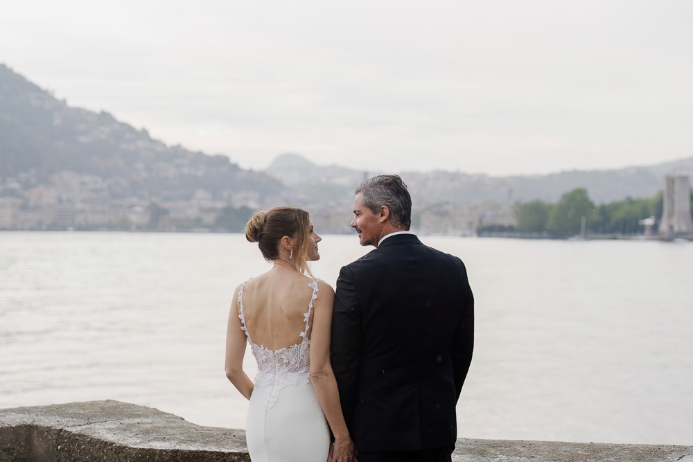 The bride and groom looking at each other, posing in front of the river lake