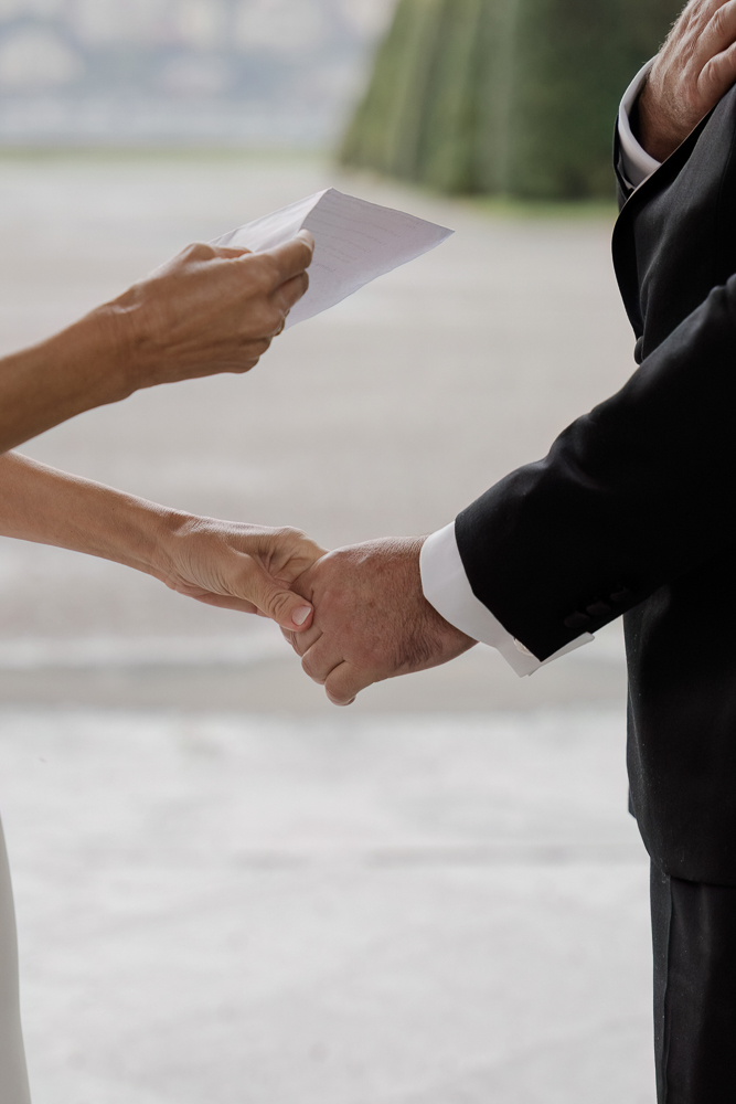 The bride reads her vows holding the groom hand