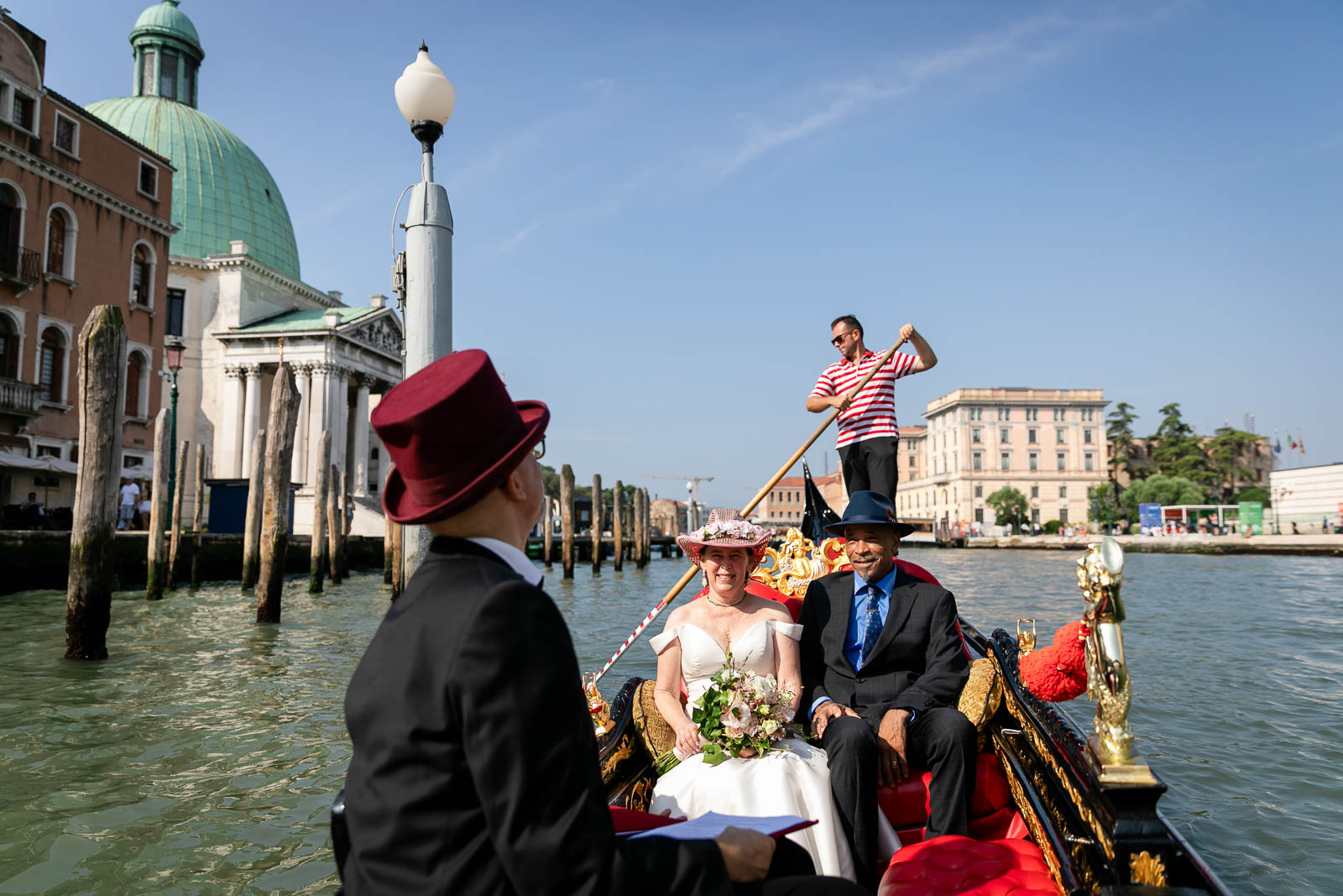 The couple start for a ceremony in a gondola in venice with ablue sky