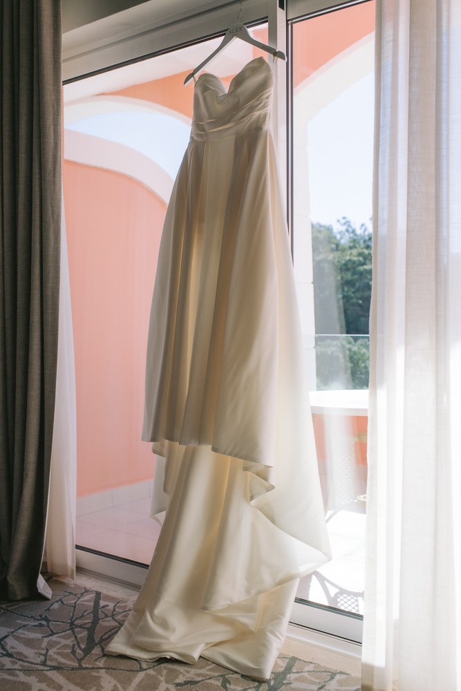 The dress of the bride hang up at the window, bckalighted