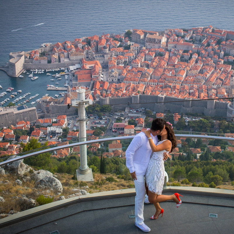 The beautiful backdrop behind the couple, a view over the sea from the balcony above the city