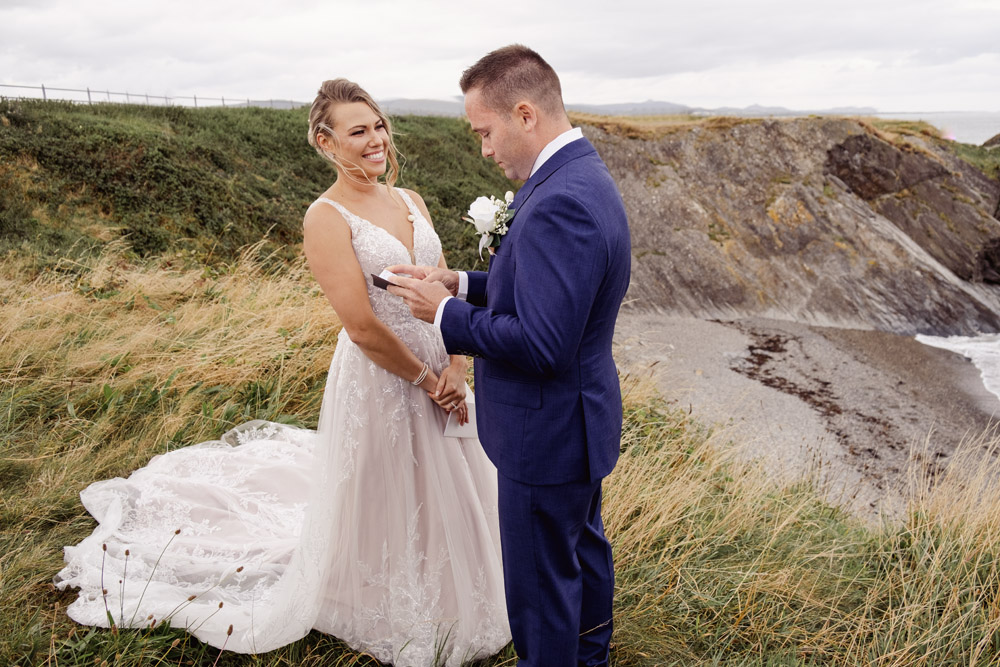 The groom reads his vows and the bride smiles