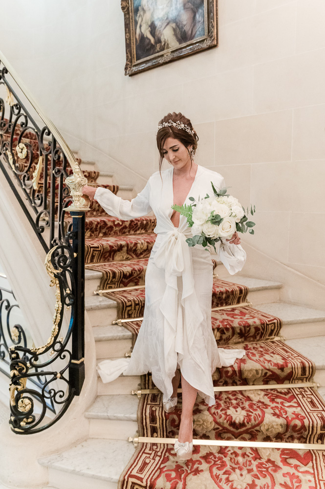 The bride going down the stair case to the car