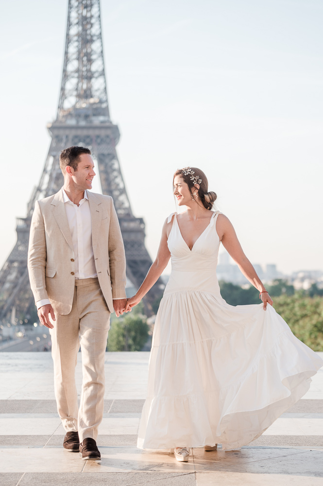 The couple walking early morning before the wedding in front of the Eiffel tower