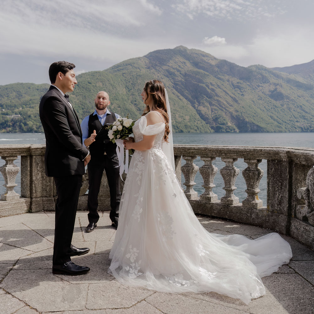 The couple during the ceremony with the celebrant over the lake