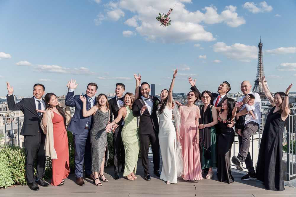 The wedding party and the bride throw the bouquet above the guests