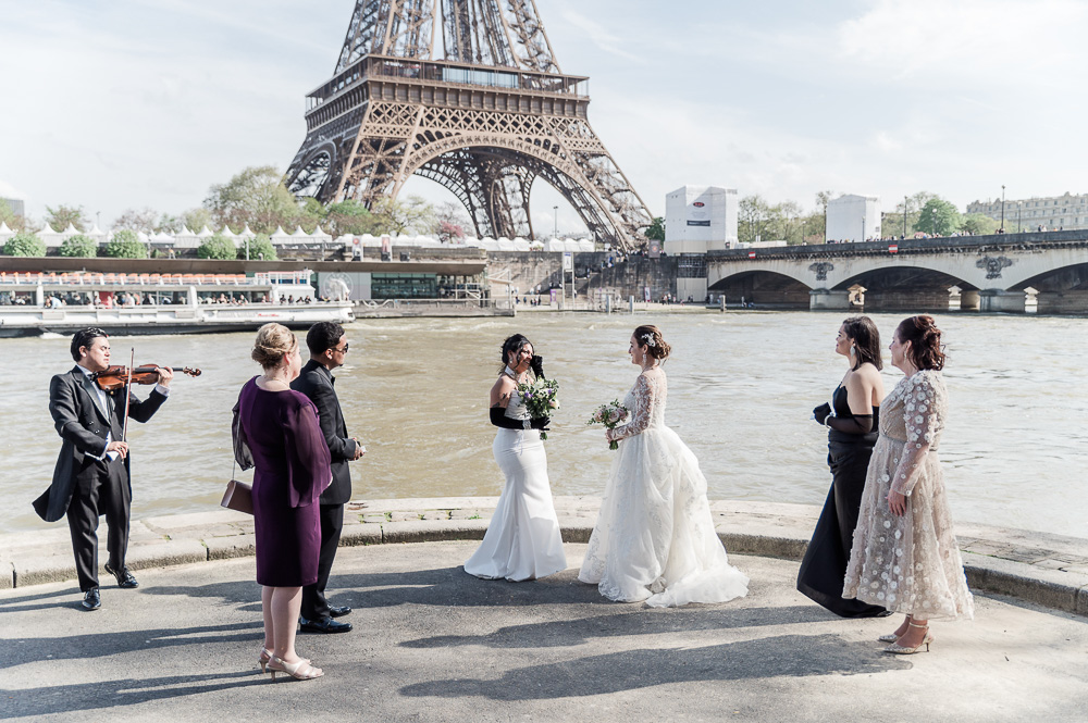 The ceremony on the river bank, the family surrounding the brides and a violonist