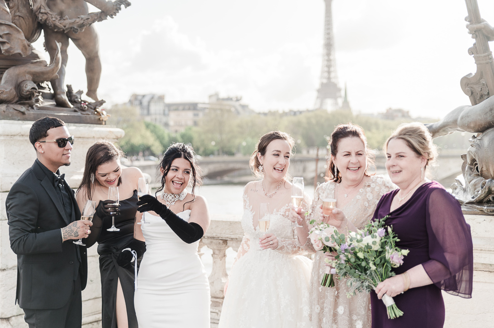 The 2 brides with their families and a glass of champagne