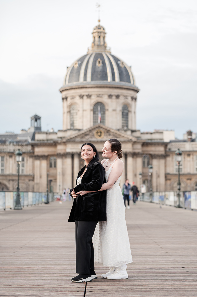 a portrait of The 2 brides on the Pont des arts early morning, with nobody around them