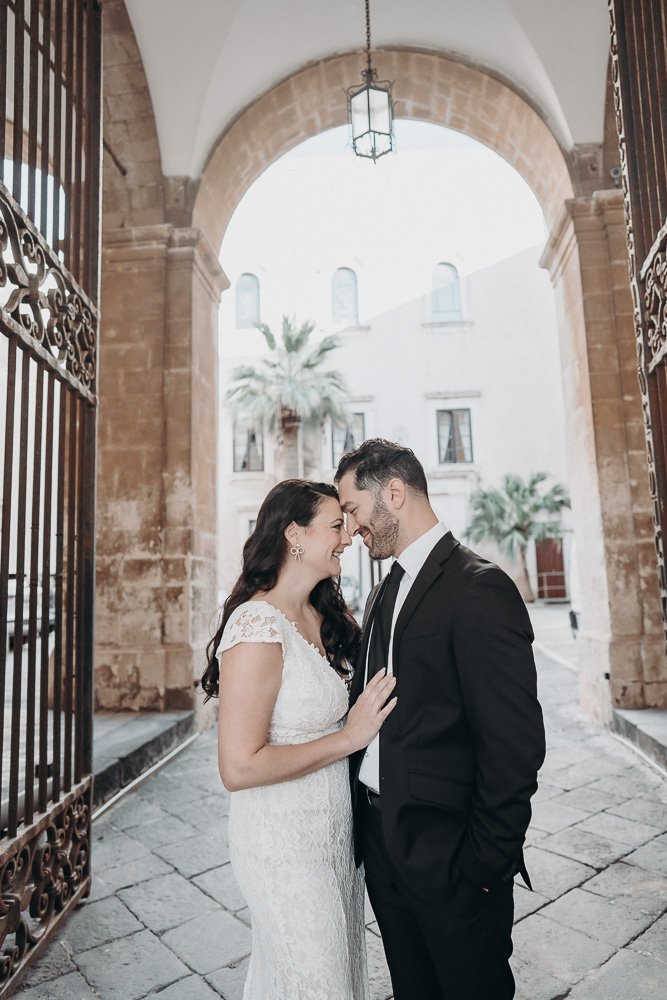 The couple posing in the city of Syracuse under an old gate, Sicily