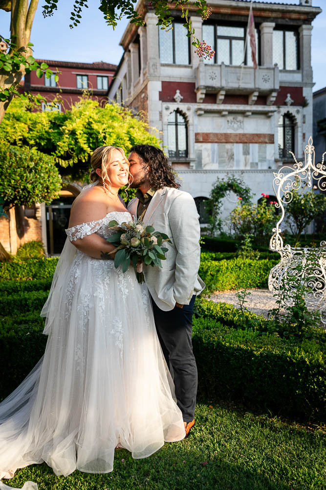 The groom kiss the bride after the wedding in the private garden in Venice