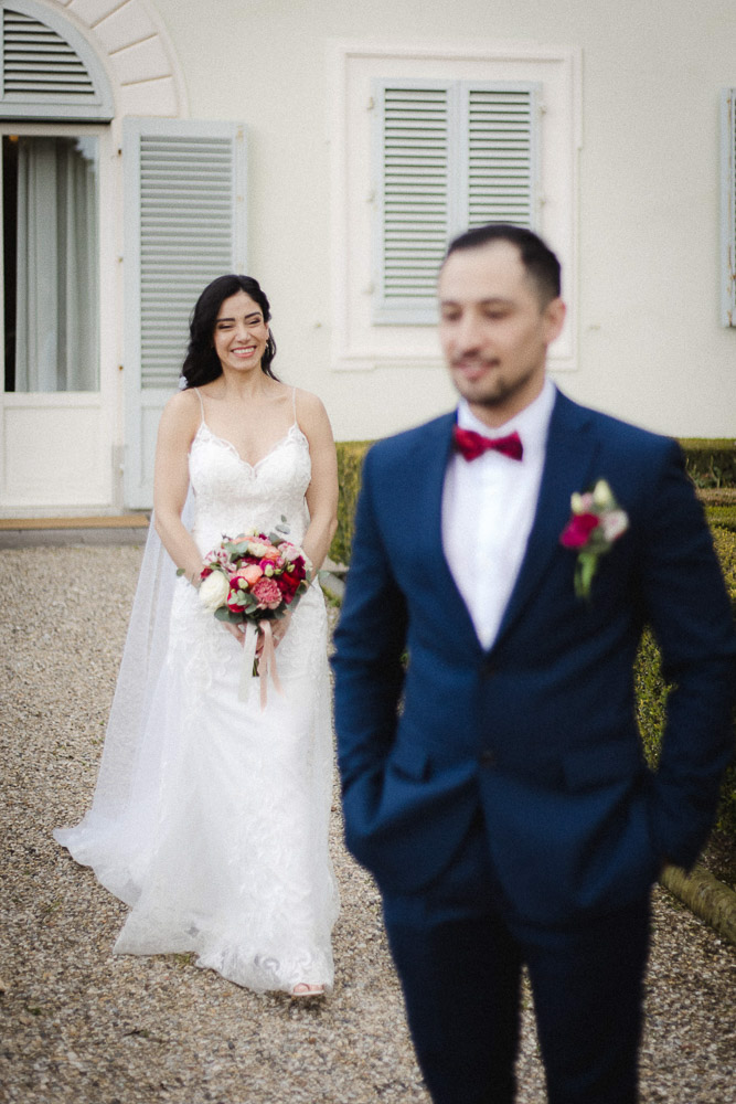 The groom wait for the bride who arrives with her bouquet